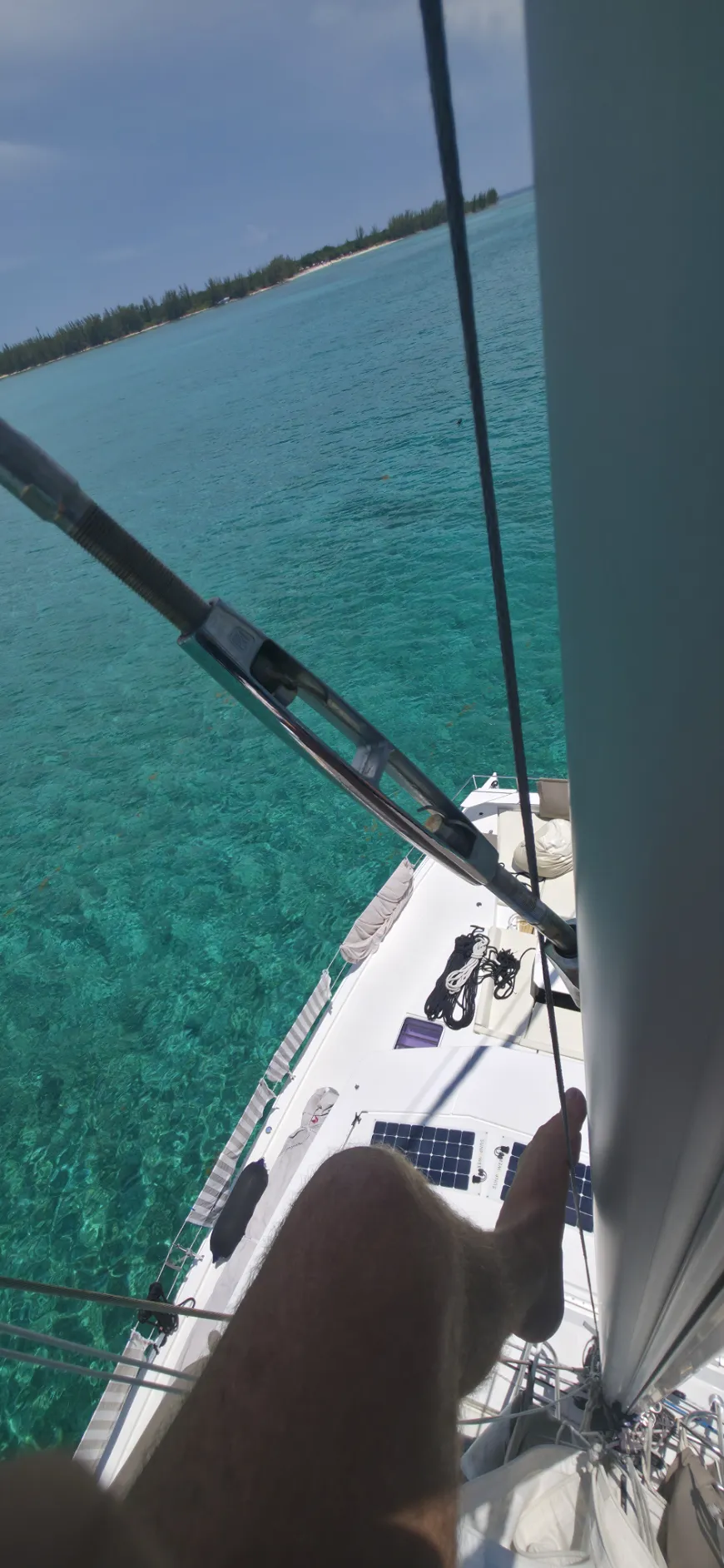 Bow of a catamaran cutting through turquoise Bahamian water